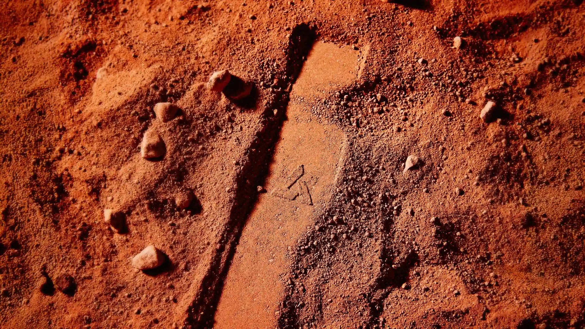 An impression in red sand of the Tempest pipe profile and Artifact logo